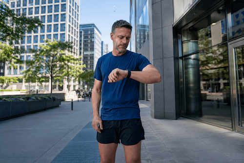 A man checking his running stats on a wearable.