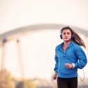 Young,Woman,Jogger,Running,By,The,River,In,The,Morning